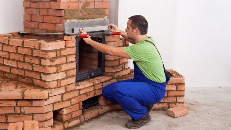 man building masonry heater