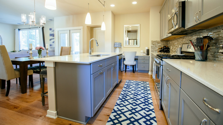 Kitchen with a navy blue and white patterned rug on the floor