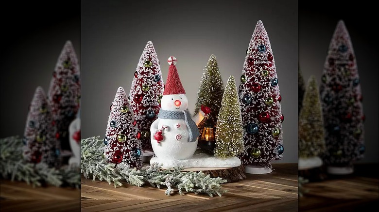 Snowman figurine surrounded by Colorful Orb Bottle Brush Trees