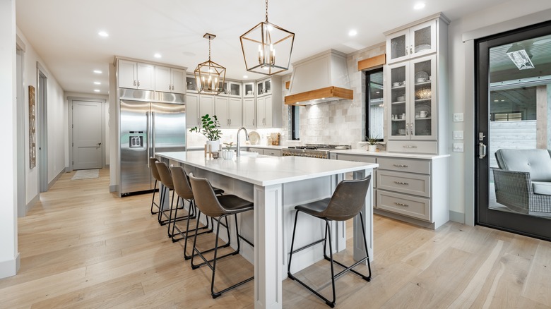 Kitchen with large island with barstools and pendant lights