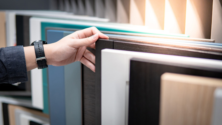 hand choosing cabinet panel materials