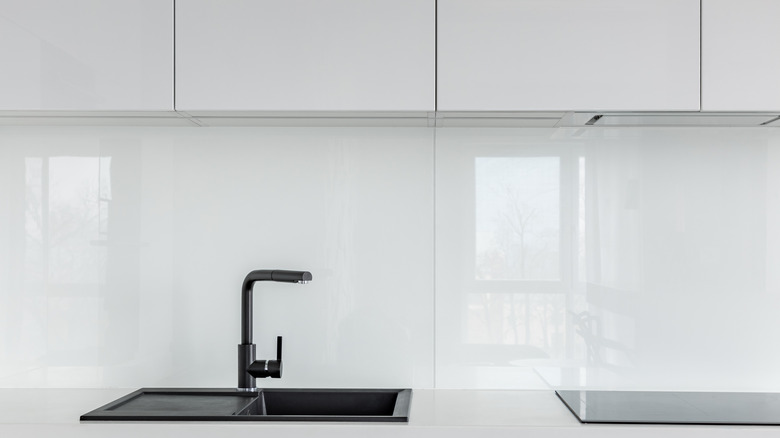 High gloss cabinets, countertop and black composite kitchen sink