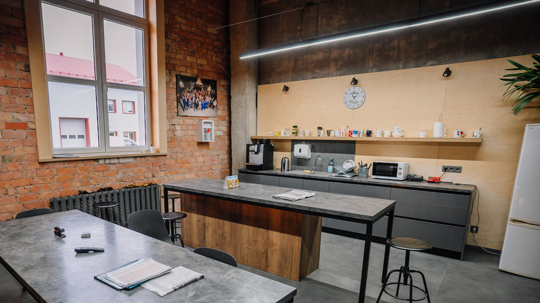 A modern industrial kitchen and dining area with exposed brick walls,