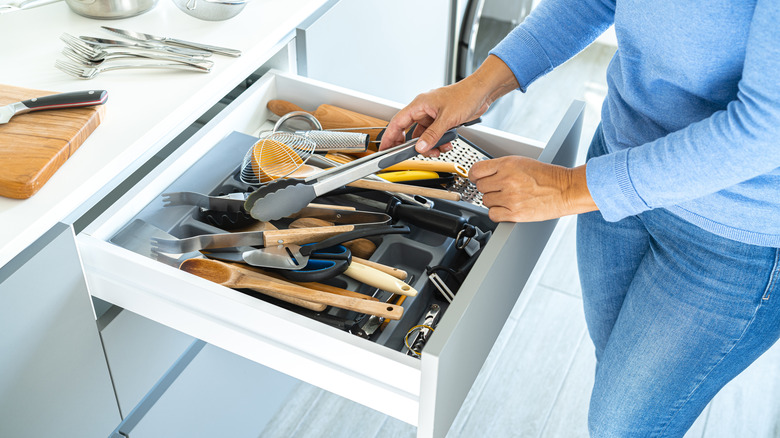 Woman organizing a kitchen drawer