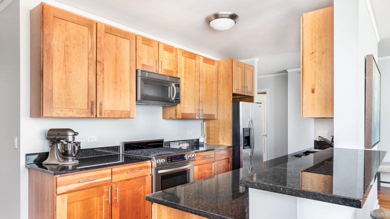 Home kitchen fitted with refrigerator, range, microwave, and stand mixer