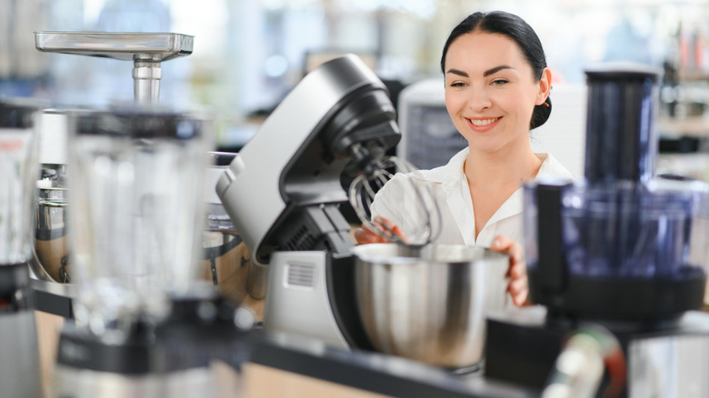 woman shopping for kitchen appliances looking at a stand mixer