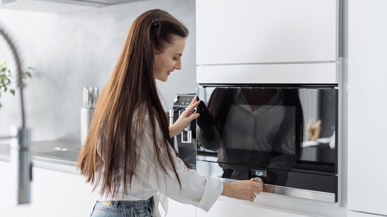 Woman using a built-in microwave