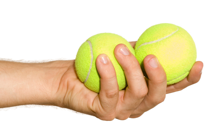 two tennis balls in hand