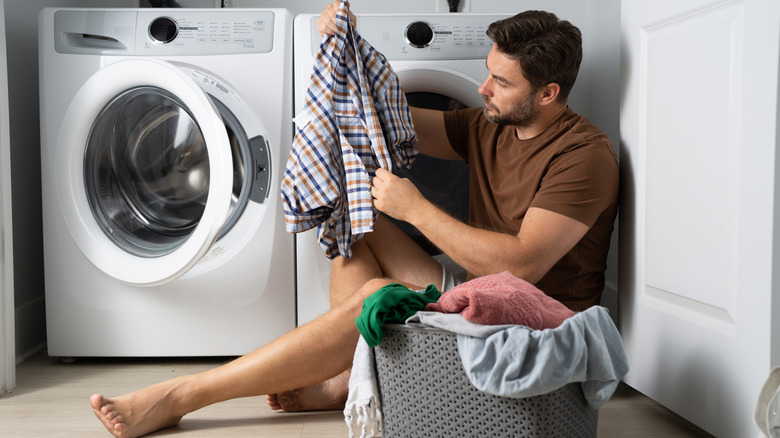 A person sorting clothes in the laundry room