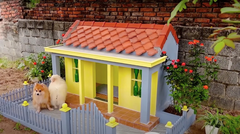 Cute yellow doghouse with fence