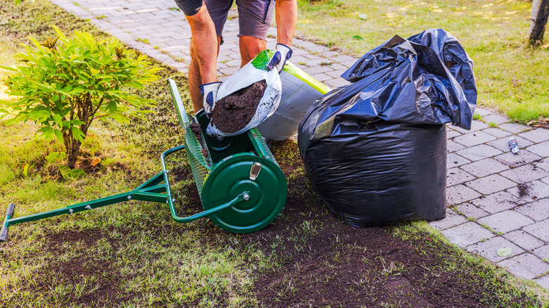 A gardener fills his spreader with compost