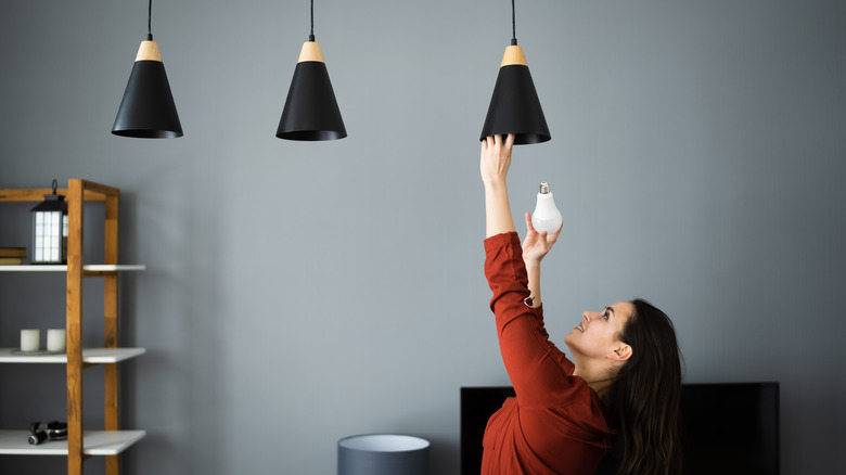 woman fixing bulb indoors