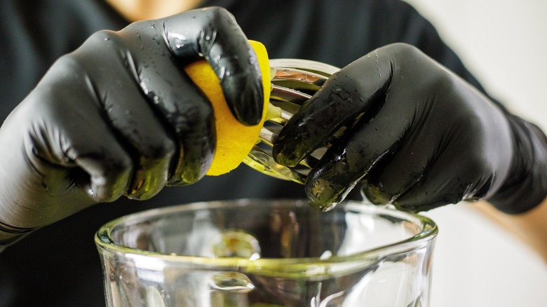 hands squeezing lemon into blender