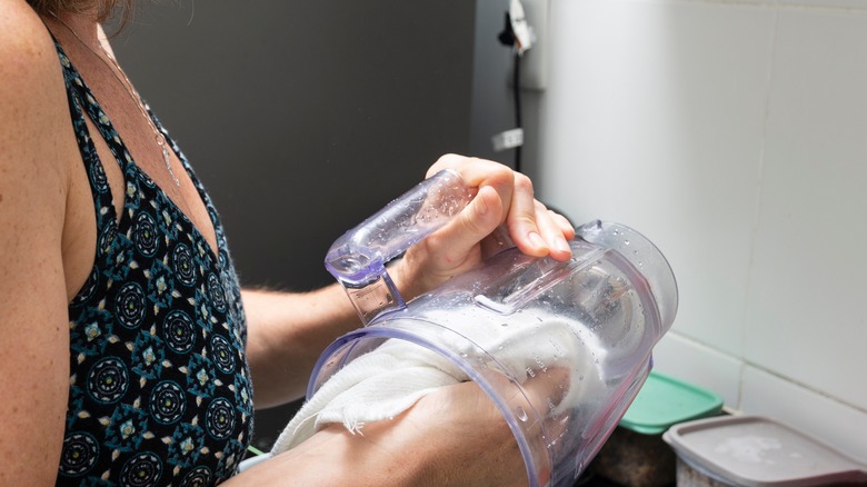 woman cleaning a blender