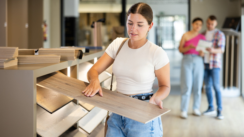 Woman looking at laminate wood-look tile in a store