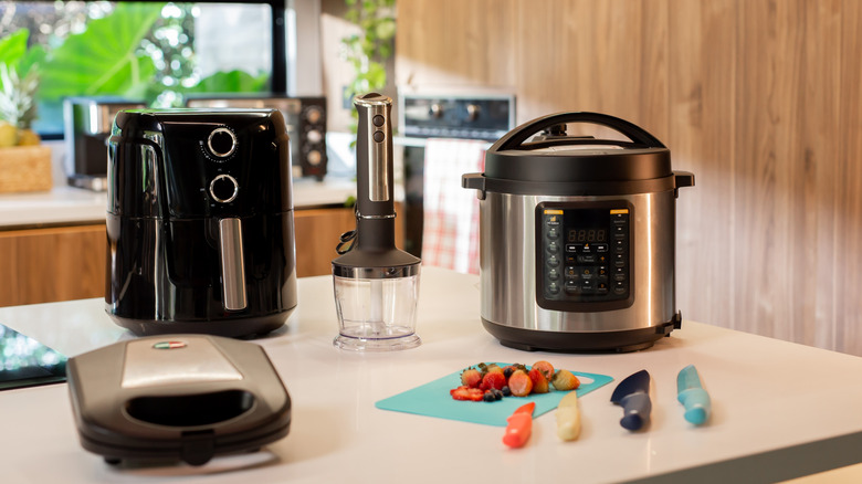 Appliances including sandwich maker and air fryer on kitchen countertop