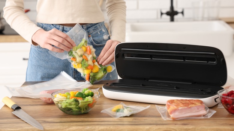 Woman vacuum-sealing vegetables