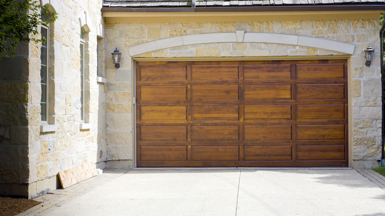 A light stone house with a large wooden garage door