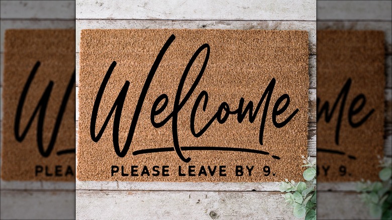 Welcome mat that says "welcome please leave by 9"