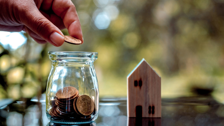 Person dropping coins into a jar