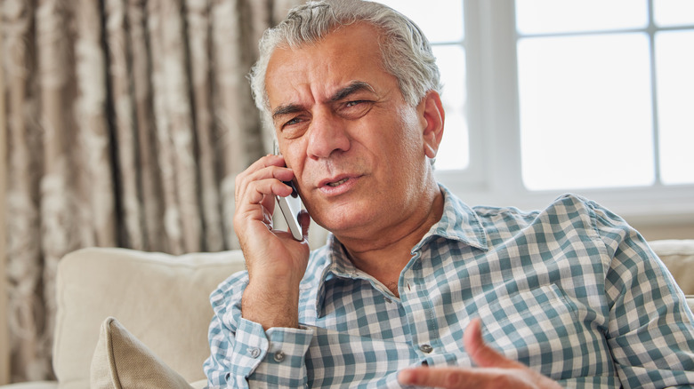 older man confused on phone