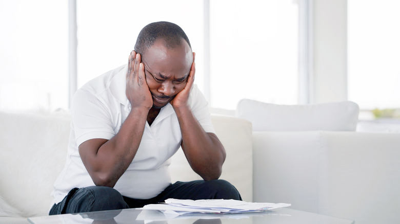 man sitting holding head