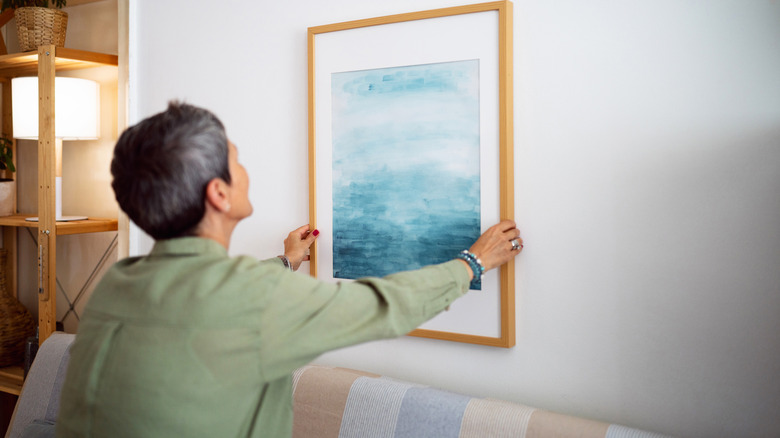 Woman decorating home with art