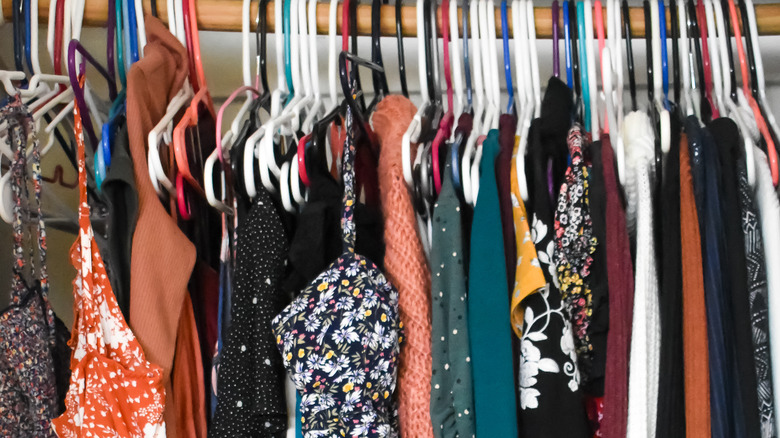 brightly-colored clothes hanging in closet