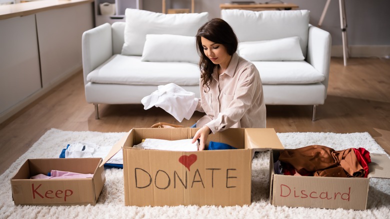 woman filling boxes to donate, discard, keep