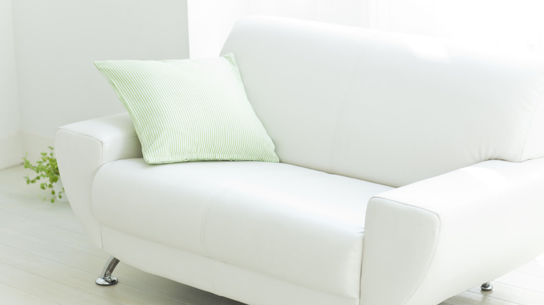White loveseat green pillow