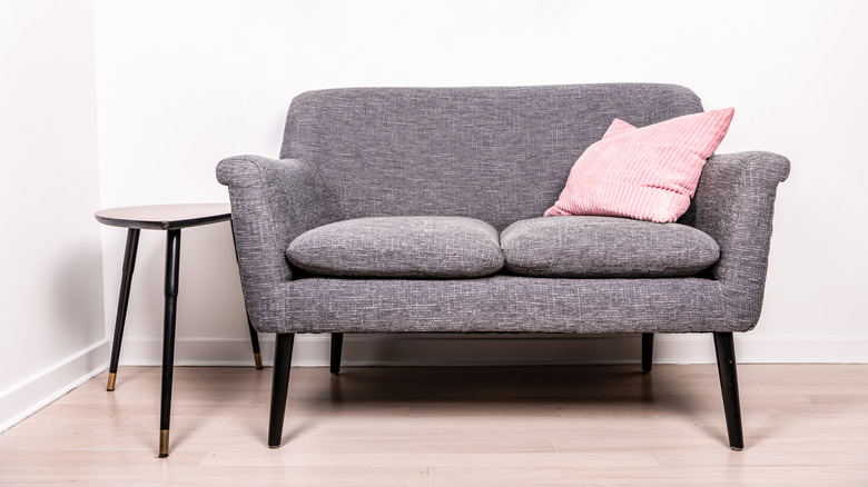 Gray loveseat with pink pillow
