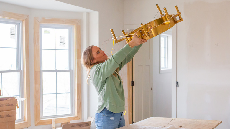 Tamara Day installing light fixture