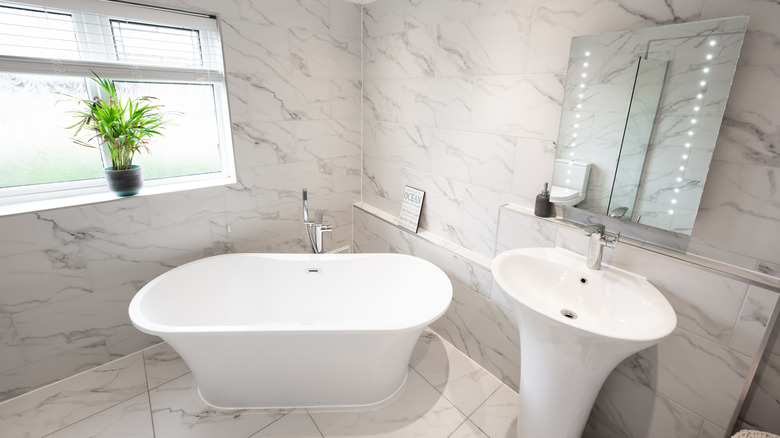 bathroom with curved tub and sink