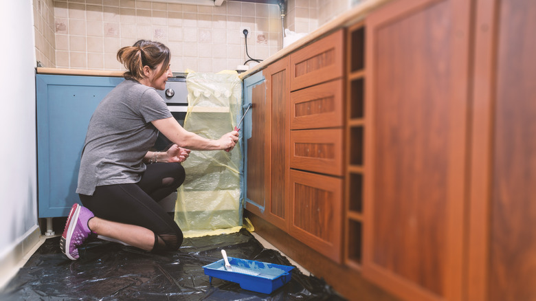 Woman painting kitchen cabinets