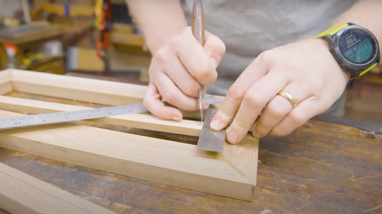 Someone working on creating a DIY wood floor vent