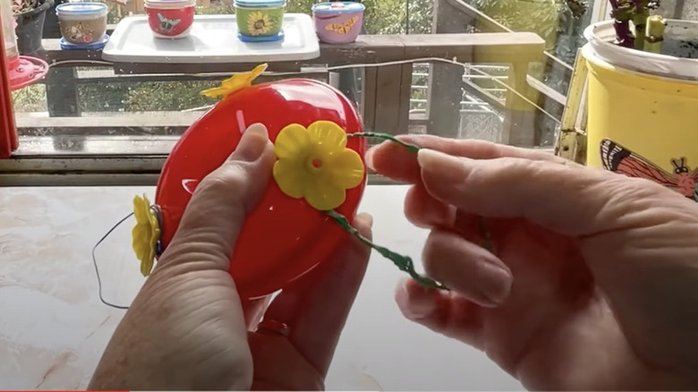 hands attaching wire to feeder