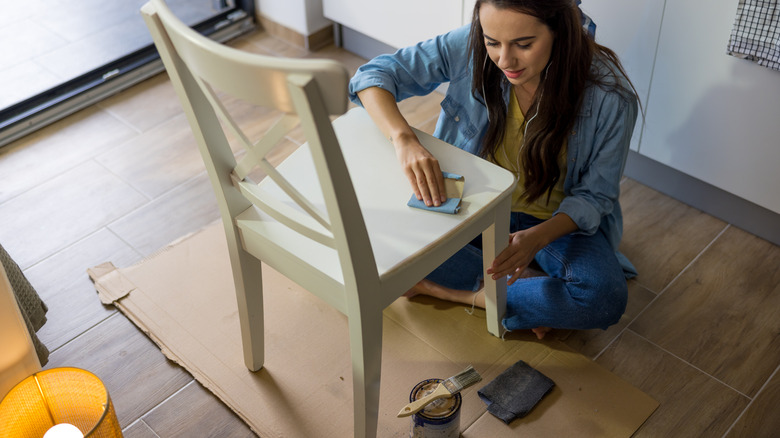 woman prepping chair for paint