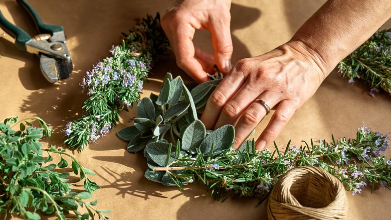 Hands assembling herbs on table