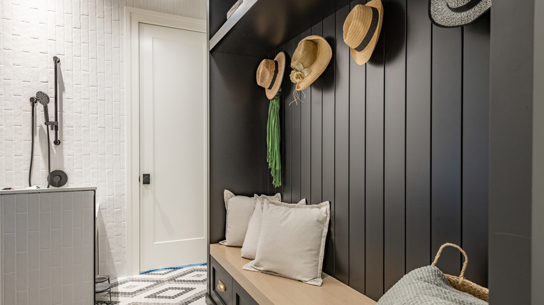 a cozy garage-turned-DIY mudroom with a pet cleaning station, storage bench, and hat hooks