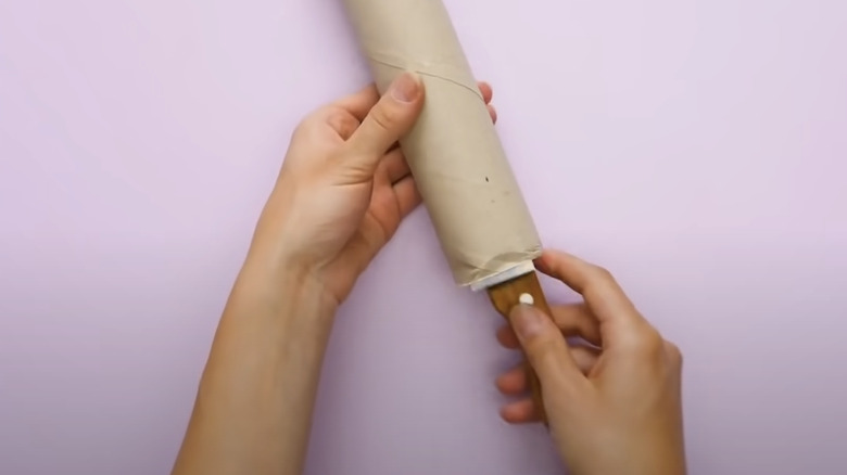 woman covering knife with paper roll