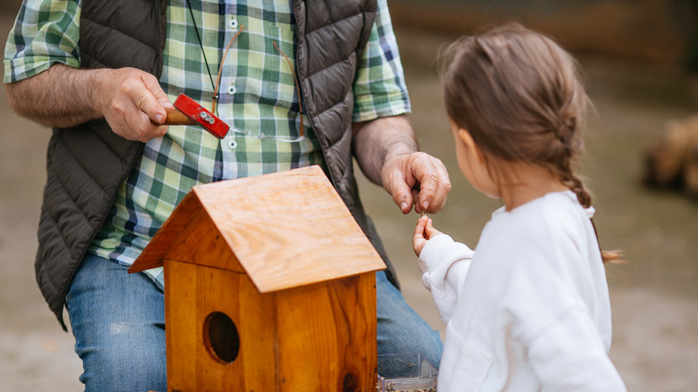 grandpa and girl building birdhouse