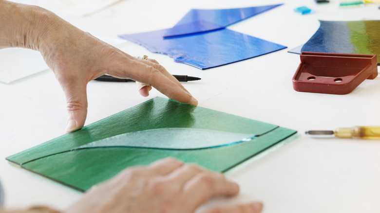 Hands working on a stained glass DIY