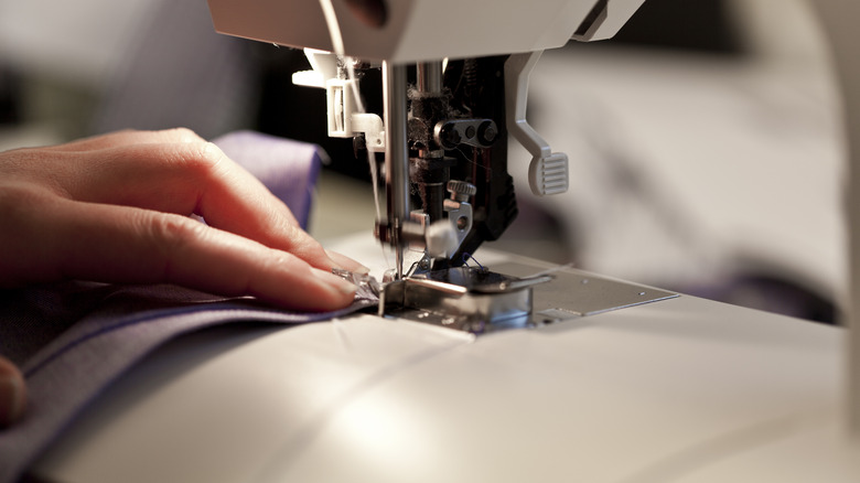 Woman sews fabric on machine