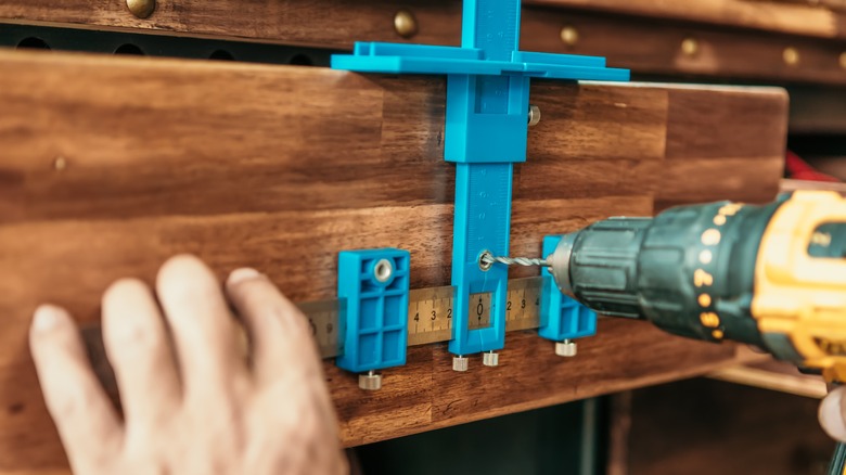 person using a cabinet hardware jig