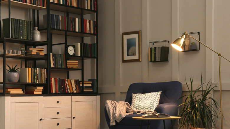 Bookshelf next to an armchair and lamp