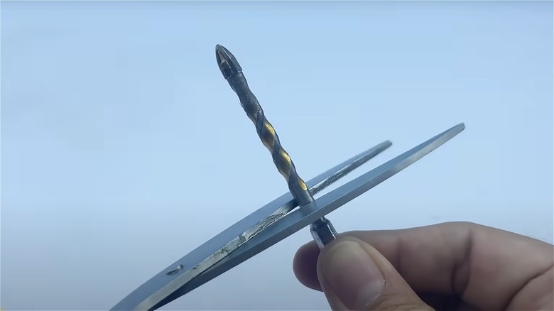 Drill bit between scissors