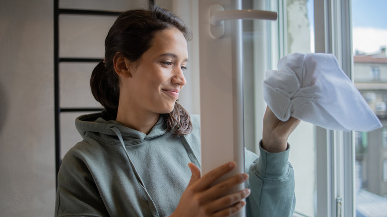 Woman smiles while wiping down window