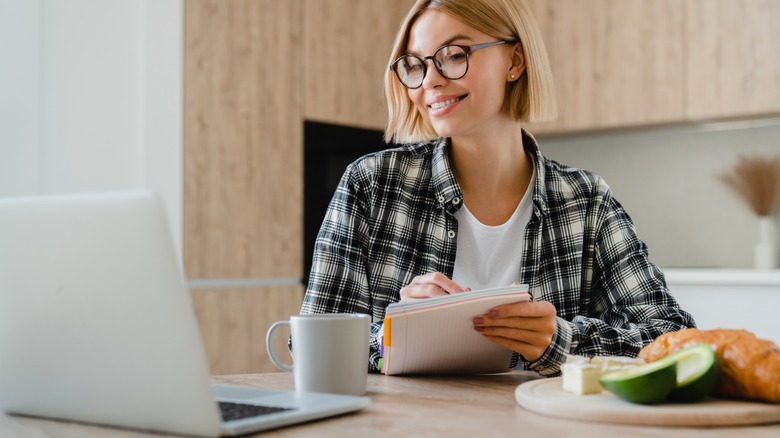 Person enjoying a meal while in a virtual work meeting