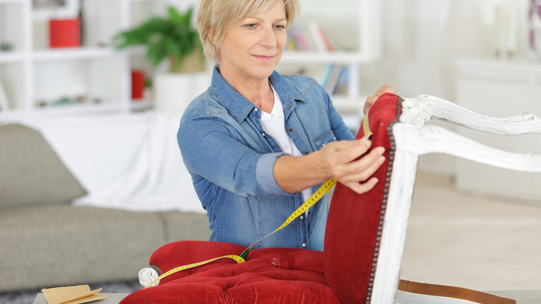 woman measuring chair for reupholstering