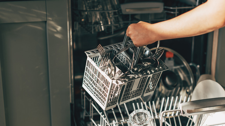 Utensil holder being placed in a dishwasher.